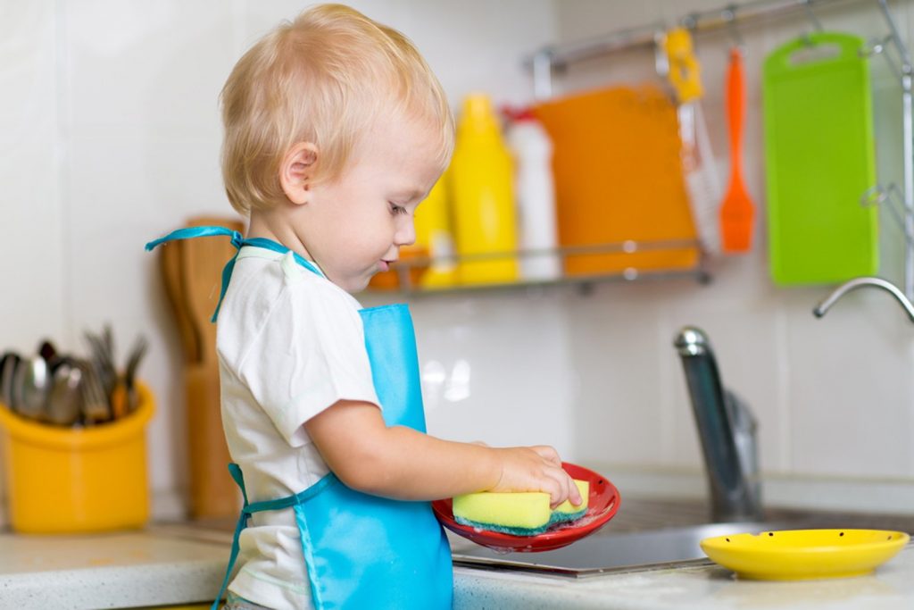 Namų ruošos darbai. Vaikas plauna indus
